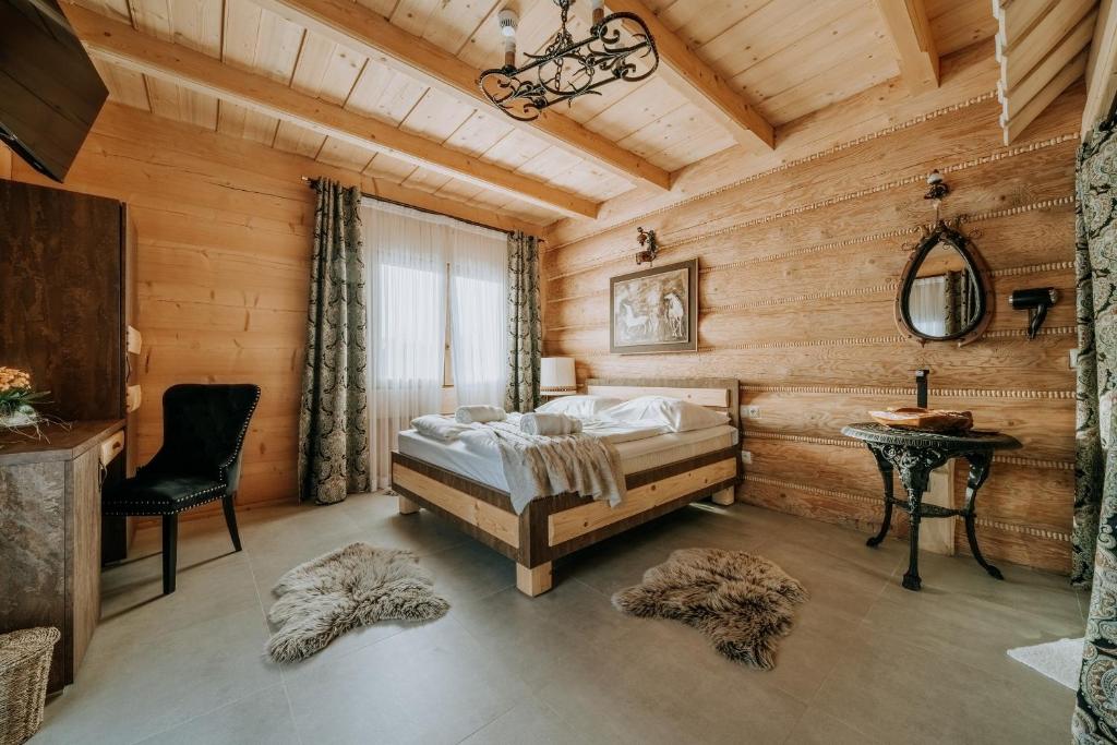 ein Schlafzimmer mit einem Bett in einem Holzzimmer in der Unterkunft Gordonówka Grand in Szaflary