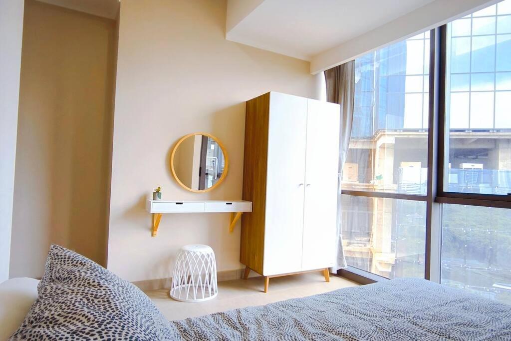 a bedroom with a mirror and a dresser next to a window at Prime Location Gem Stylish 2BR at Menara Jakarta in Jakarta