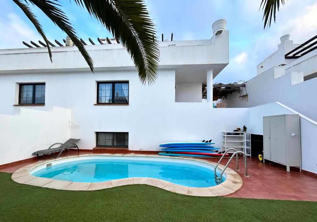 a swimming pool in front of a house at Surf&Sleep in Corralejo