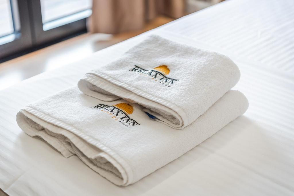 two towels sitting on top of a bed at Relax Inn Hotel Durres in Durrës