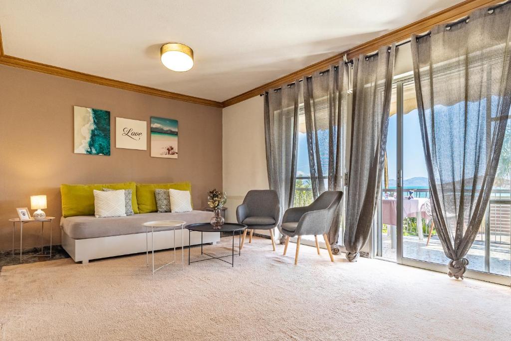 een woonkamer met een bank en een tafel en stoelen bij Almyros Sea Front Villa in Míloi