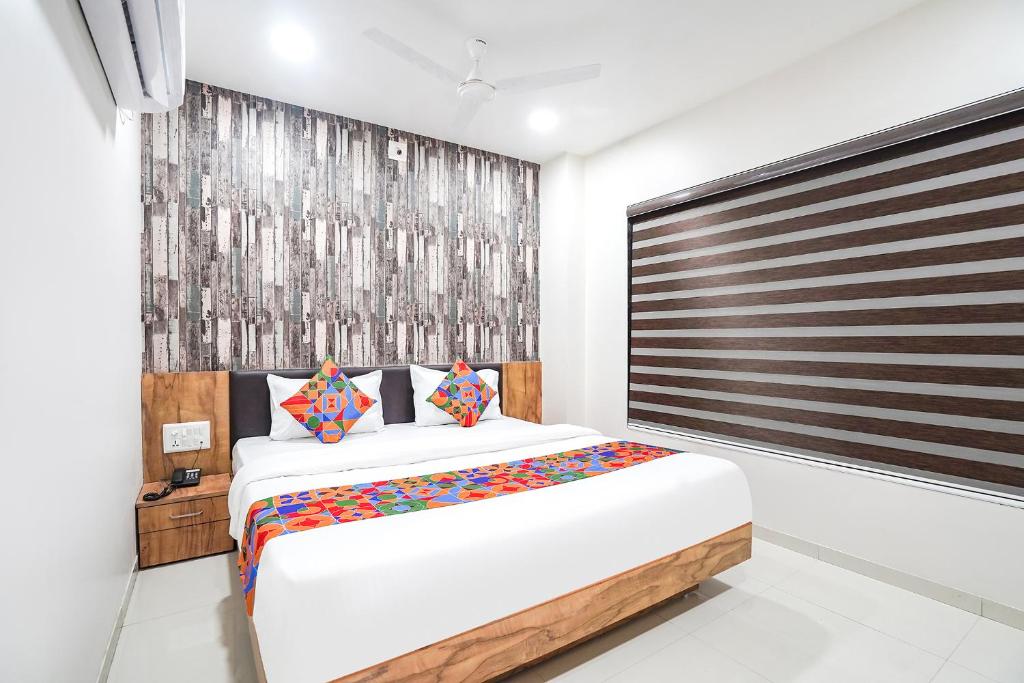 ein Schlafzimmer mit einem großen Bett und einem großen Fenster in der Unterkunft FabHotel Prime Palace View in Vadodara