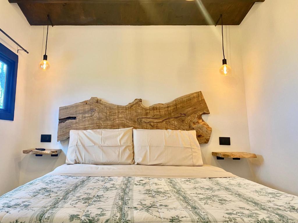 1 dormitorio con 1 cama con cabecero de madera en Sotto L'Ulivo en Montepulciano