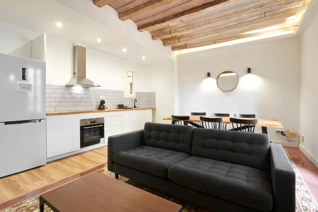 a living room with a couch and a kitchen at Comfortable apartment next to Apolo theater in Barcelona