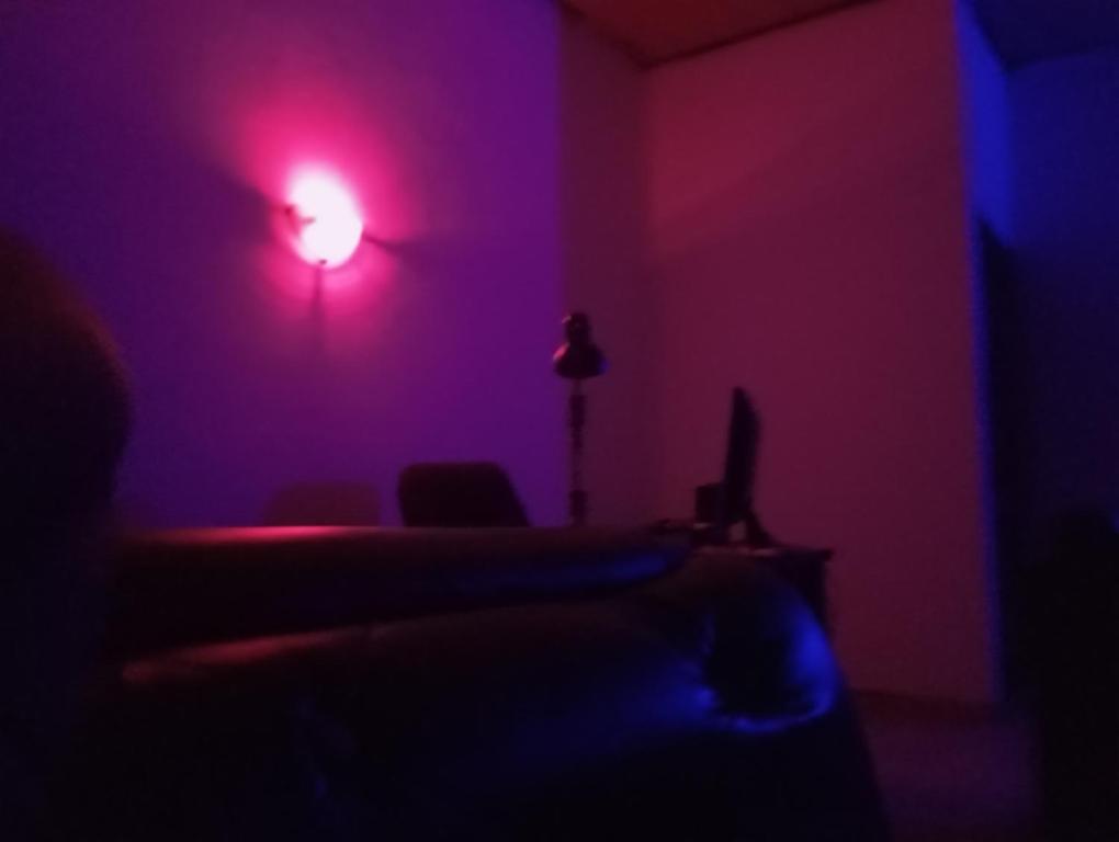 ein dunkles Zimmer mit rotem Licht an der Wand in der Unterkunft Crale and Busino in Port Harcourt