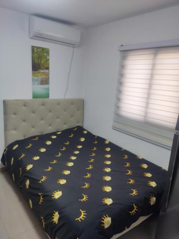 a bedroom with a bed with a black comforter and a window at נוף ים אילת in Eilat