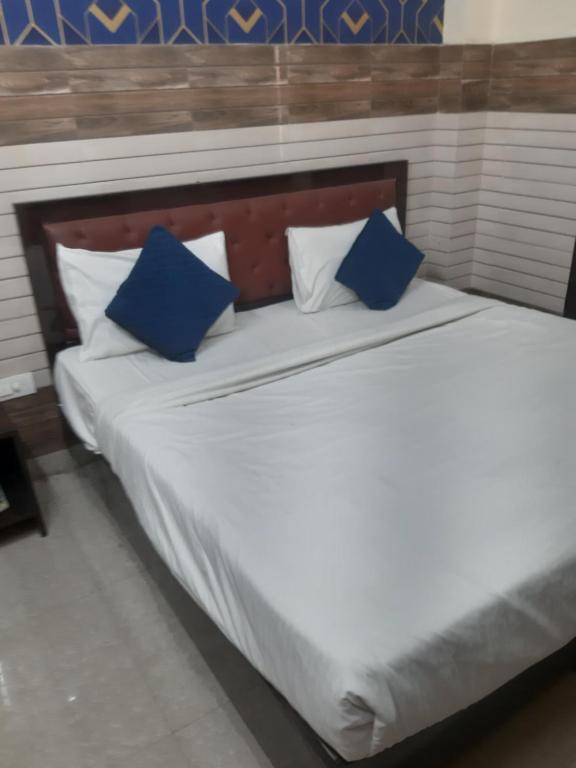 a bed with blue and white pillows on it at Diamond Imperial in Noida