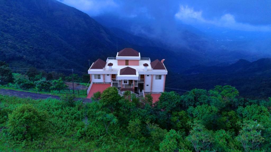 a house on top of a hill in the mountains at Blossom Bed Resort Vagamon by Lexstays in Vagamon