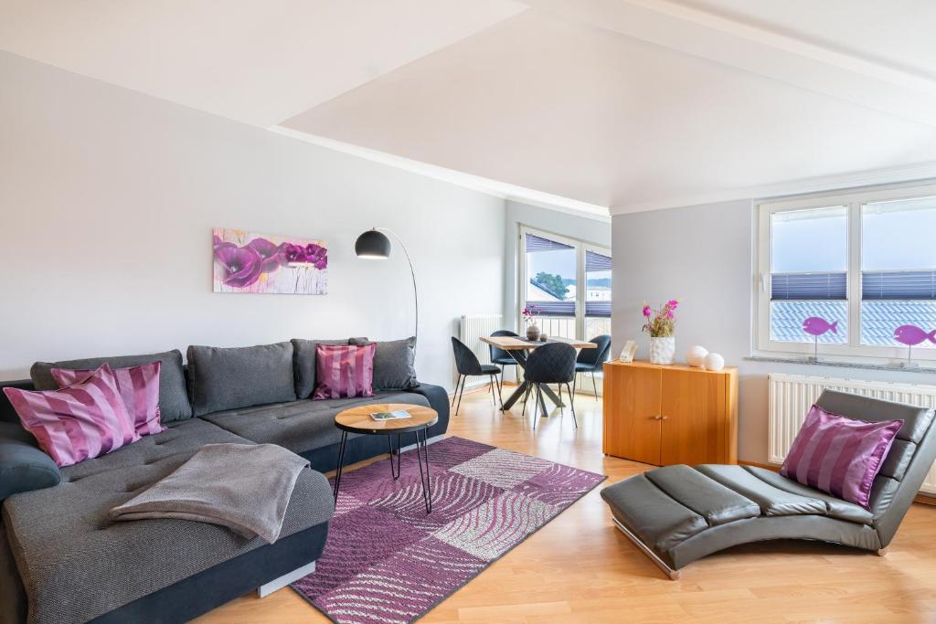 - un salon avec un canapé gris et des oreillers roses dans l'établissement Villa Alt_Ahlbeck, à Ahlbeck