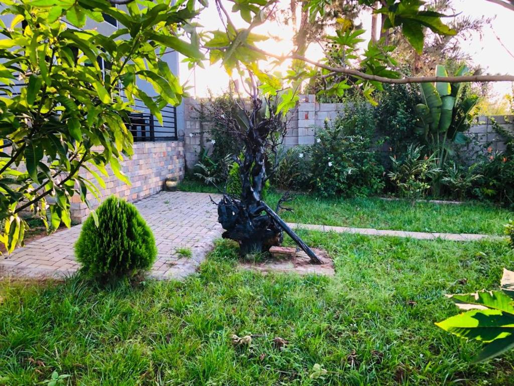 a garden with a statue in the grass at Malixa Lofts in Wakiso
