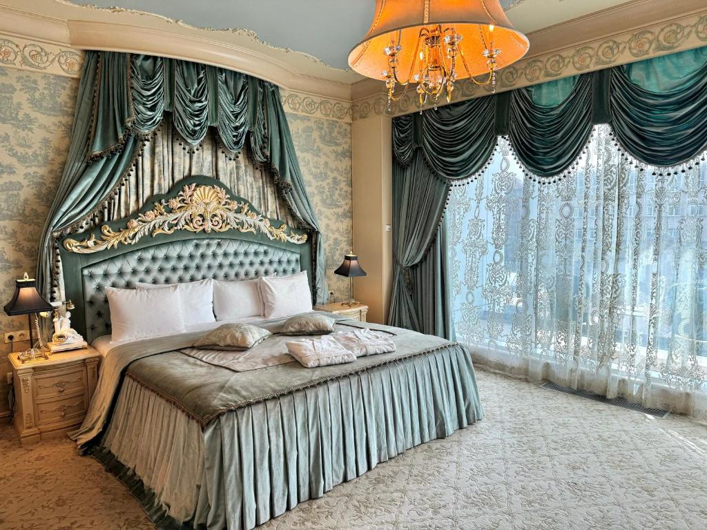 a bedroom with a large bed and a chandelier at Royal SPA & Hotel Resort in Riga