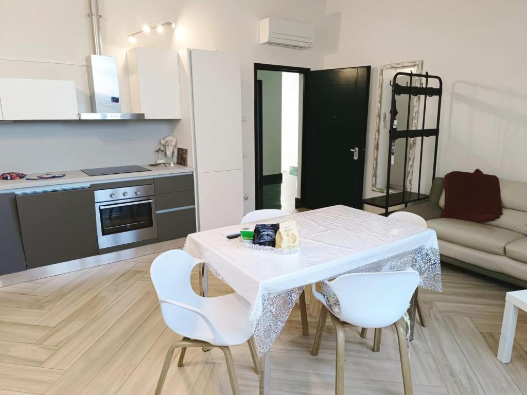 eine Küche und ein Wohnzimmer mit einem weißen Tisch und Stühlen in der Unterkunft Residenza Martignoni Ex Antica Oasi Francescana in Varese