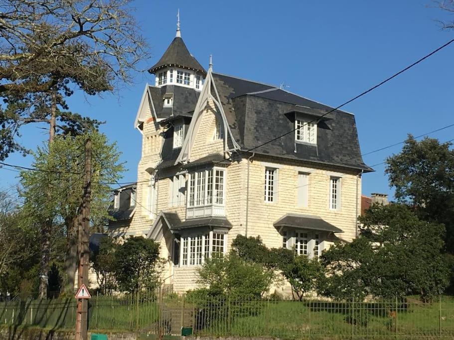 een groot wit huis met een zwart dak bij Villa La Clairière in Royan