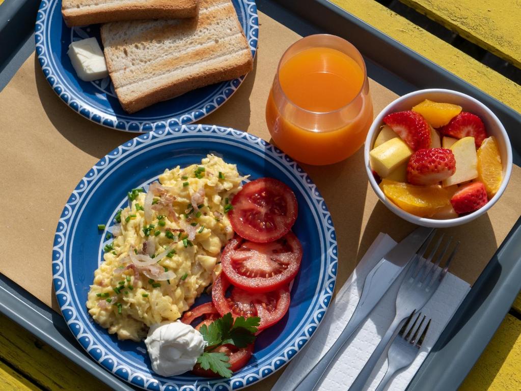 a table with two plates of food and a bowl of fruit at Lobby Collective Hostel - Lecce in Lecce