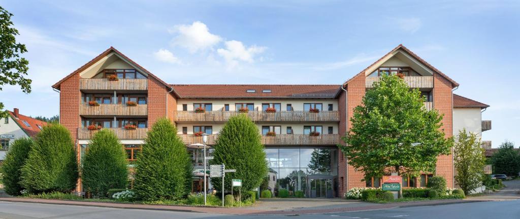 ein großes Backsteingebäude mit Bäumen davor in der Unterkunft Landhotel Annelie in Preußisch Oldendorf