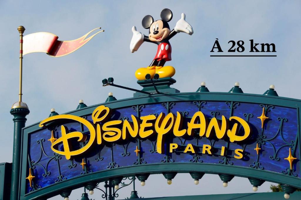 una señal para desfiles de Disneyland con un ratón en la parte superior en Chambre d’hôte à 13 minutes de Disneyland, en Champs-Sur-Marne