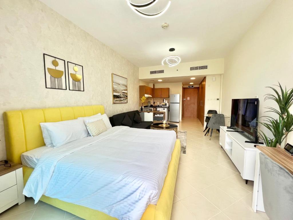 ドバイにあるCosmos Living Stunning Apt in Lago Vista IMPZのベッドルーム(大型ベッド1台付)、リビングルームが備わります。