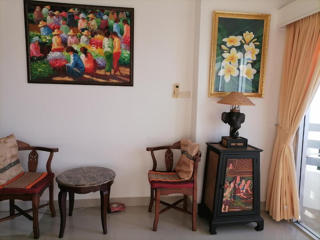 a room with chairs and a painting on the wall at Beachfront Cozy Studio in Ban Phe