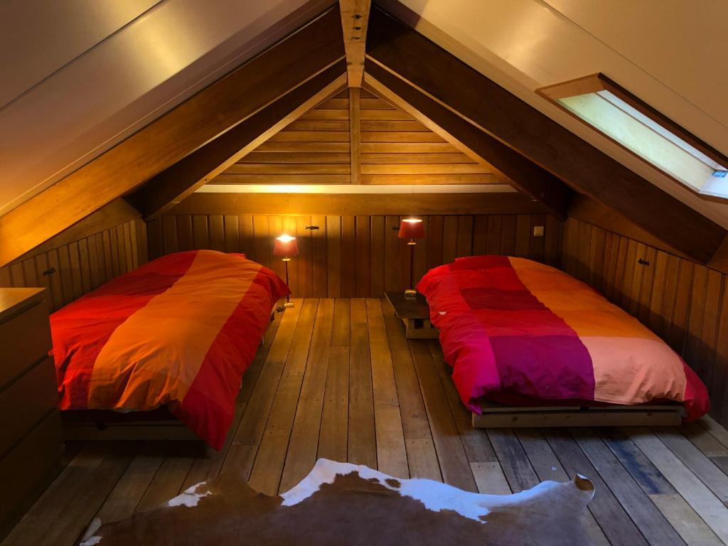 a room with two beds in a attic at Tempat Hutan in Lochem