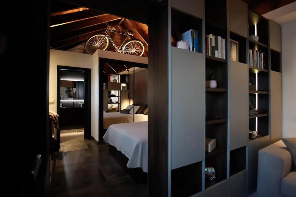 sypialnia z łóżkiem i półką na książki w obiekcie Komodo Gran Poder - Penthouse with Private Pool and Cozy twin bedroom central Apartment w Sewilli