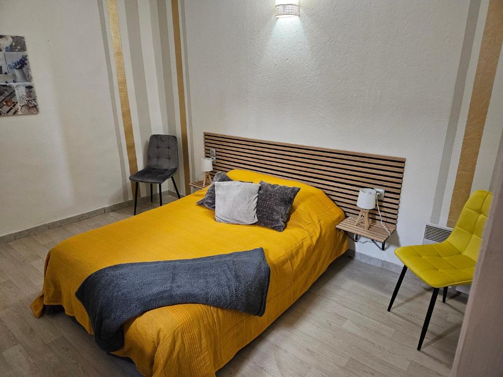 1 Schlafzimmer mit einem gelben Bett und 2 Stühlen in der Unterkunft Bono plages récemment rénové février 2024 in Mèze