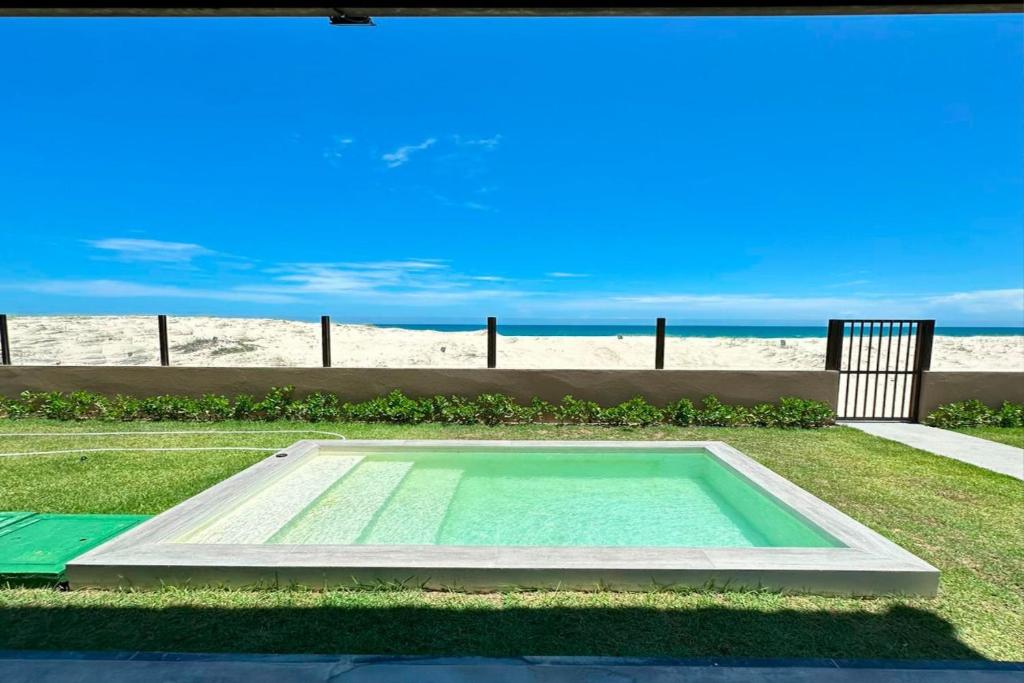 a swimming pool in front of the beach at Beachfront Duplex #A10 em Barro Preto by Carpediem in Prainha