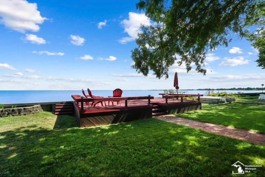 a picnic table with a view of the ocean at Restored historic log cabin & deck on Lake Erie in Luna Pier