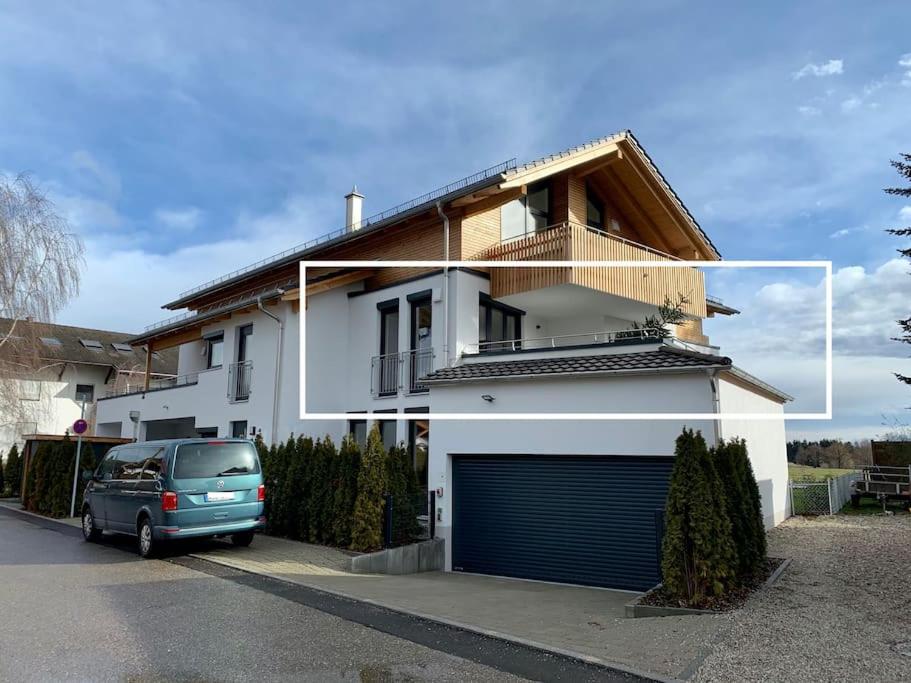 a van parked in front of a white house at Luxusappartement Hochries - 106qm mit sonniger Dachterrasse in Bad Aibling