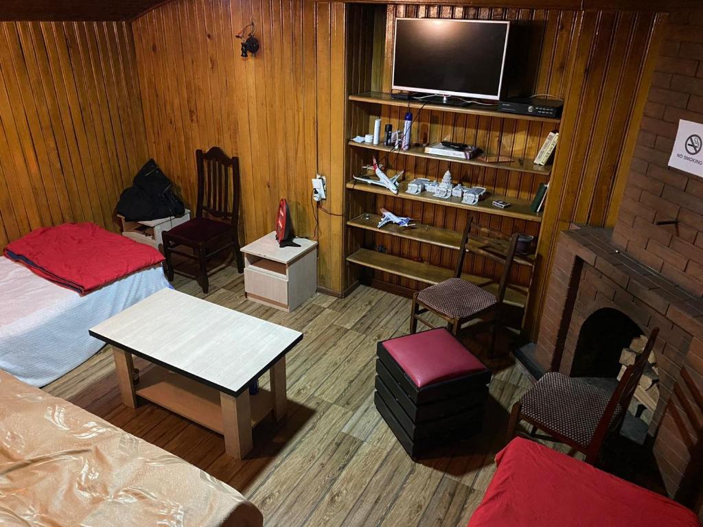 a room with two beds and a tv and a fireplace at ARTISHA TRAVEL TBILISI in Tbilisi City