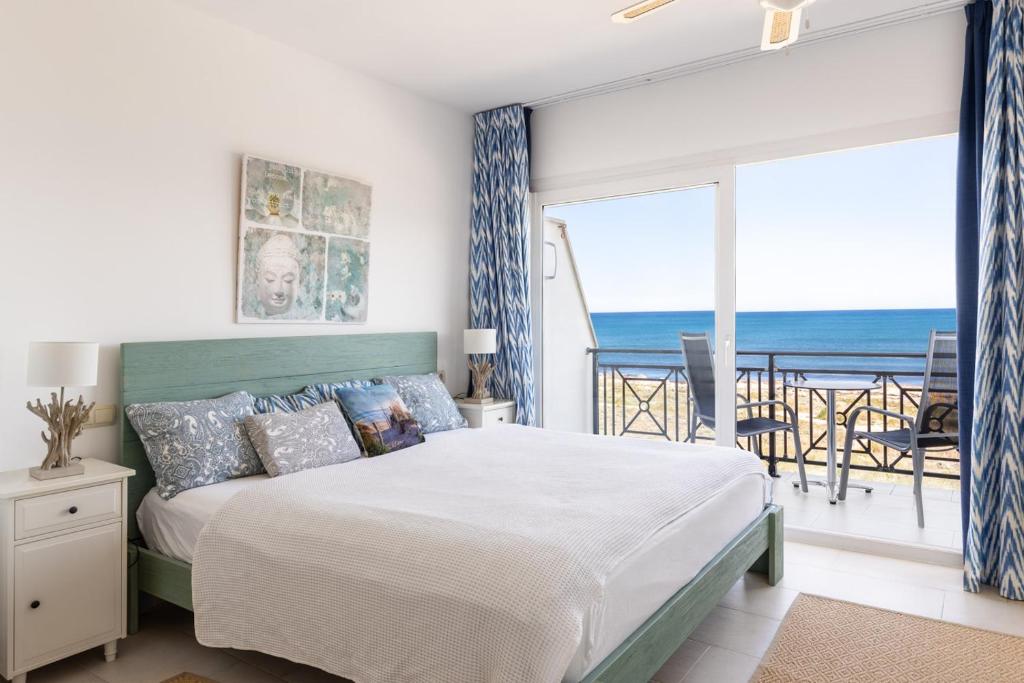 a bedroom with a bed and a view of the ocean at Beach house in 1st sea line of Son Serra in Son Serra de Marina