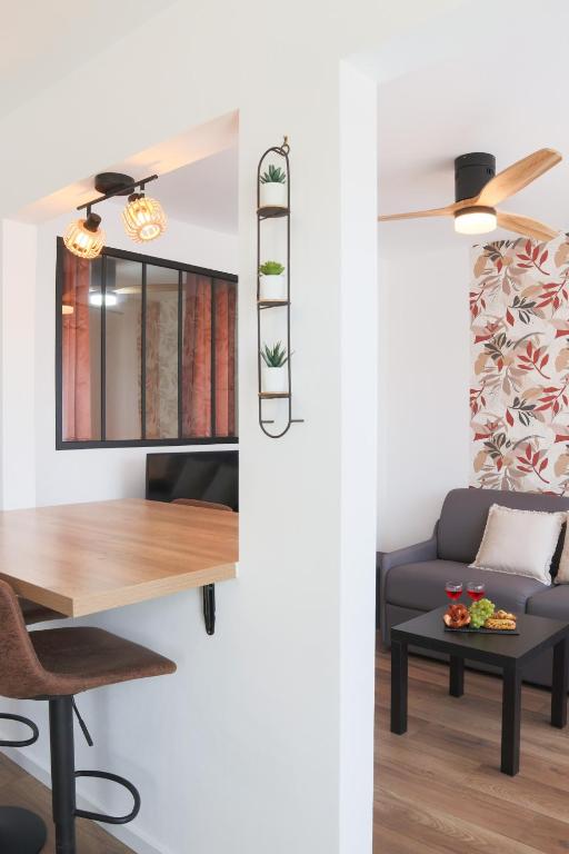 un salon avec une table et un canapé dans l'établissement L'Escale cosy, proche Euroairport, à Saint-Louis