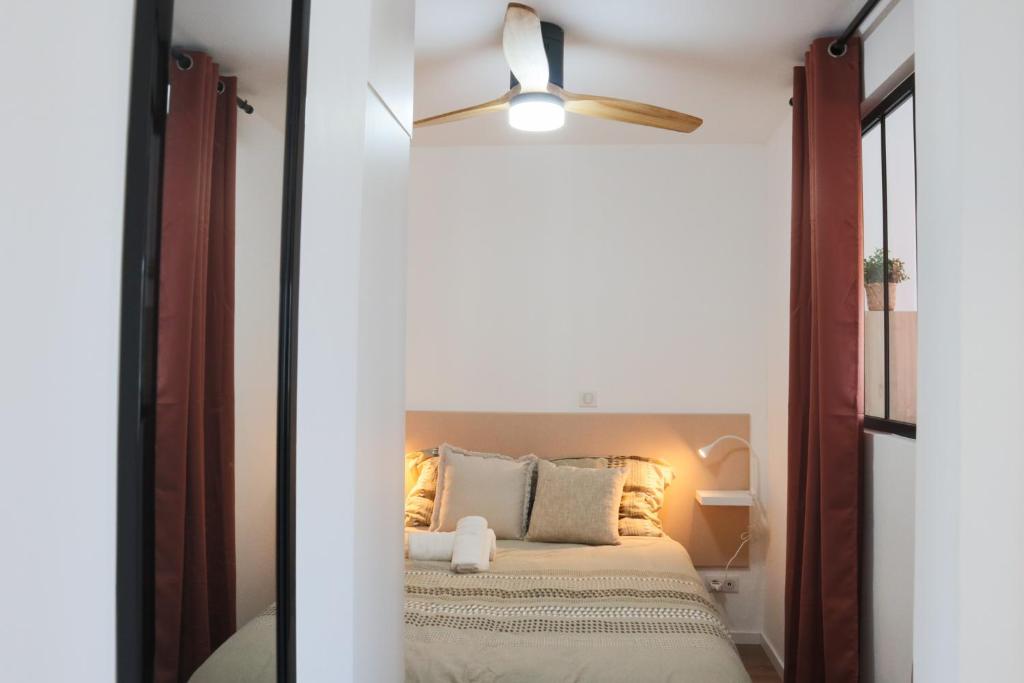 a bedroom with a bed and a ceiling fan at L'Escale cosy, proche Euroairport in Saint-Louis