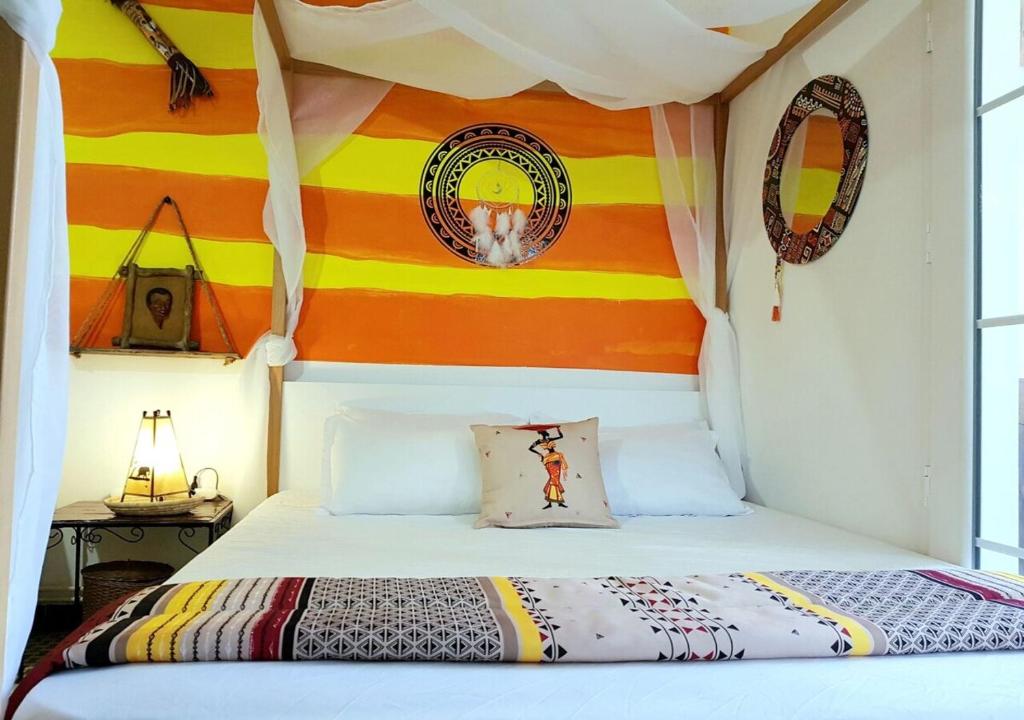 1 dormitorio con 1 cama con una pared colorida en The African Story en La Marsa