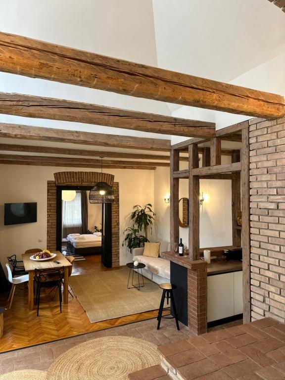 una sala de estar con una pared de ladrillo y una mesa en Marvellous Cozy Villa in Old Center Town Brasov, en Brasov