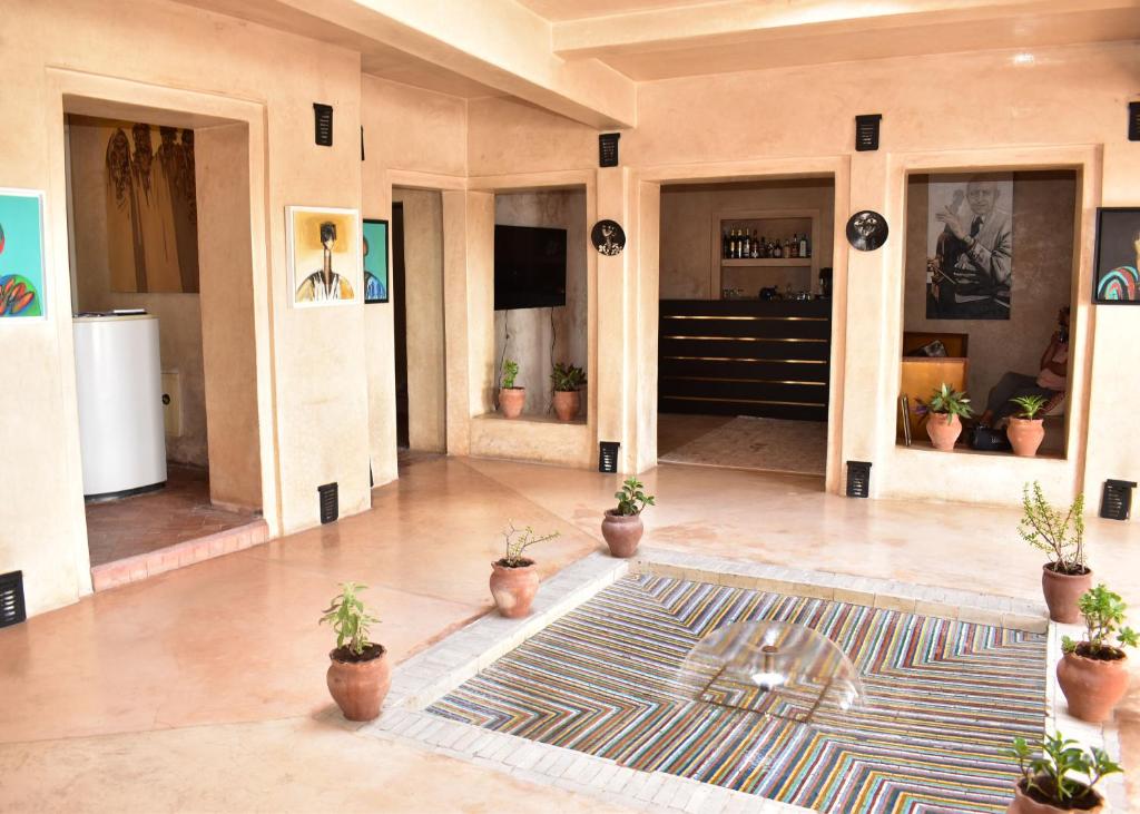 un vestíbulo con macetas y una alfombra en el suelo en L'Oum Errebia, en Azemmour