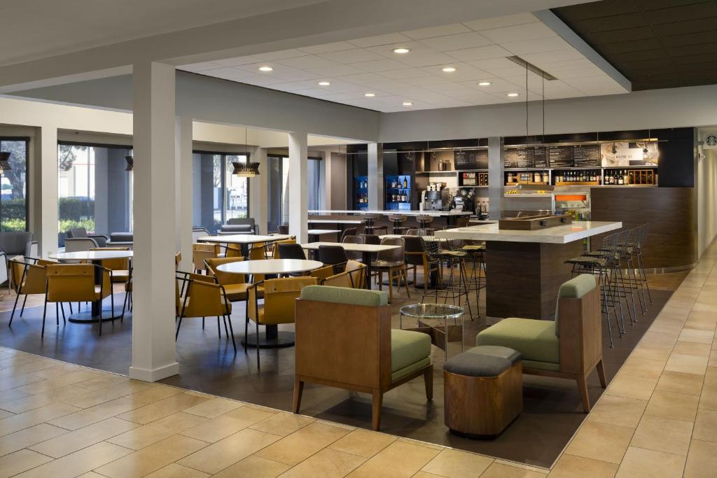 um restaurante com mesas e cadeiras e um bar em Courtyard by Marriott San Mateo Foster City em Foster City