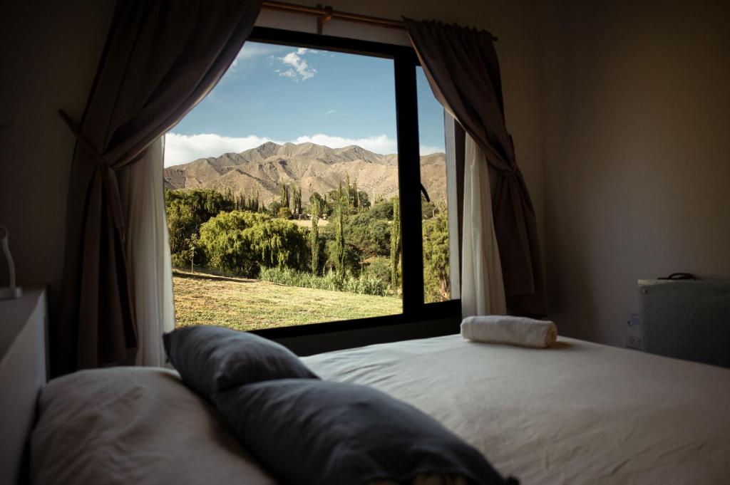 a bedroom with a window with a mountain view at La Pascana in Cachí