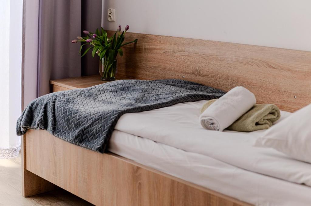 a bed with a wooden headboard with towels on it at Centrum Wypoczynku i Rekreacji Rysy Krynica Zdrój in Krynica Zdrój