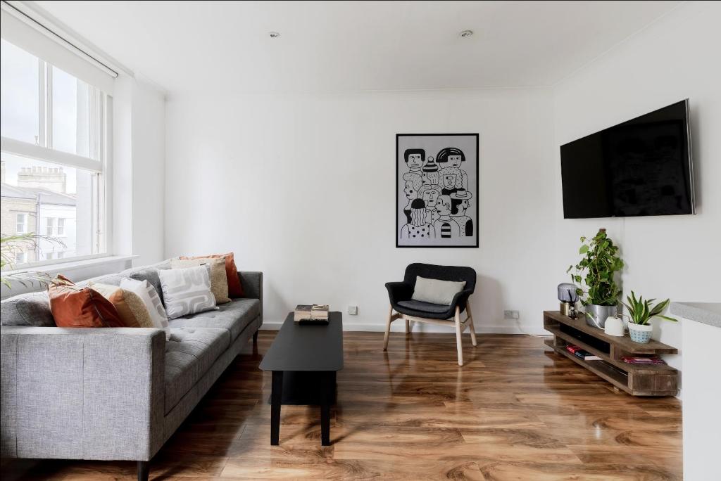 ein Wohnzimmer mit einem Sofa und einem Tisch in der Unterkunft Primrose Hill Charming 1-Bed Flat in London