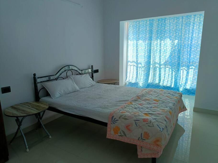 um quarto com uma cama e uma janela em Zanita Heights Seaview Apt em Bogmalo