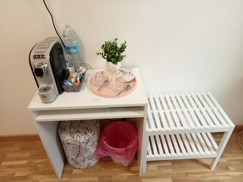 een kleine witte tafel met een naaimachine en een wastafel bij Fenix Rooms in Trieste