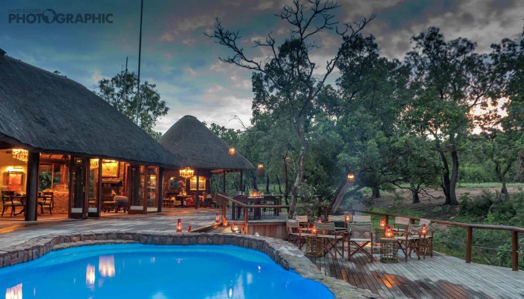 a resort with a swimming pool at night at Ndlovu Safari Lodge in Welgevonden Game Reserve