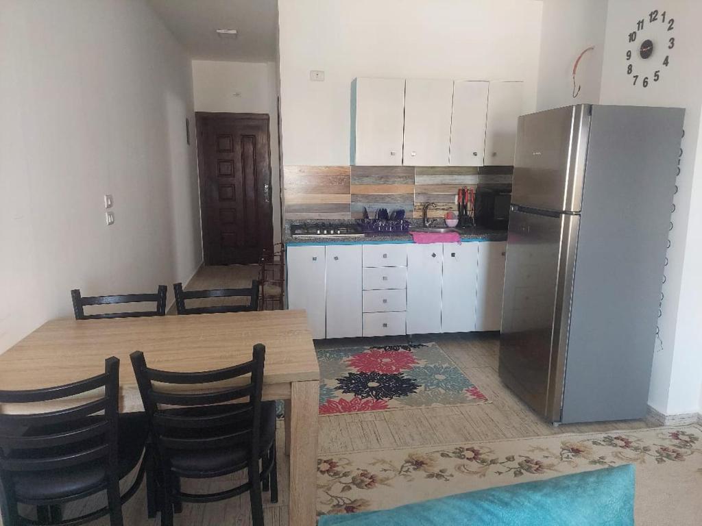 a kitchen with a wooden table and a refrigerator at Al makramia compound in Hurghada