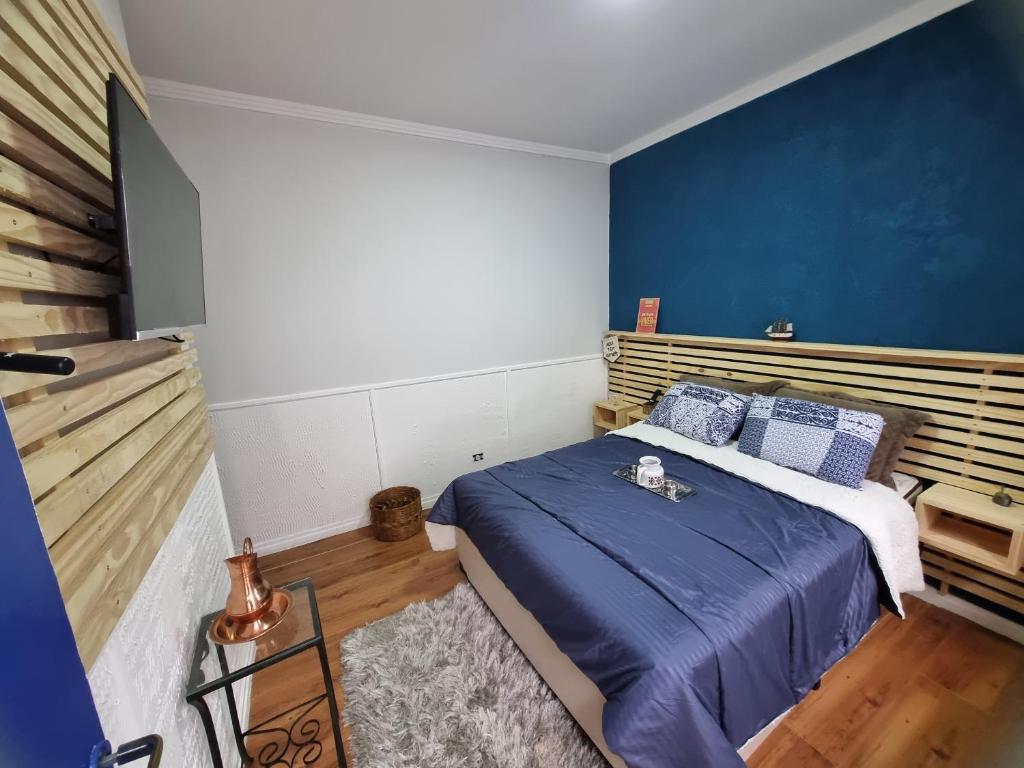 um quarto com uma cama e uma parede azul em Loft no Butantã, próximo a USP em São Paulo
