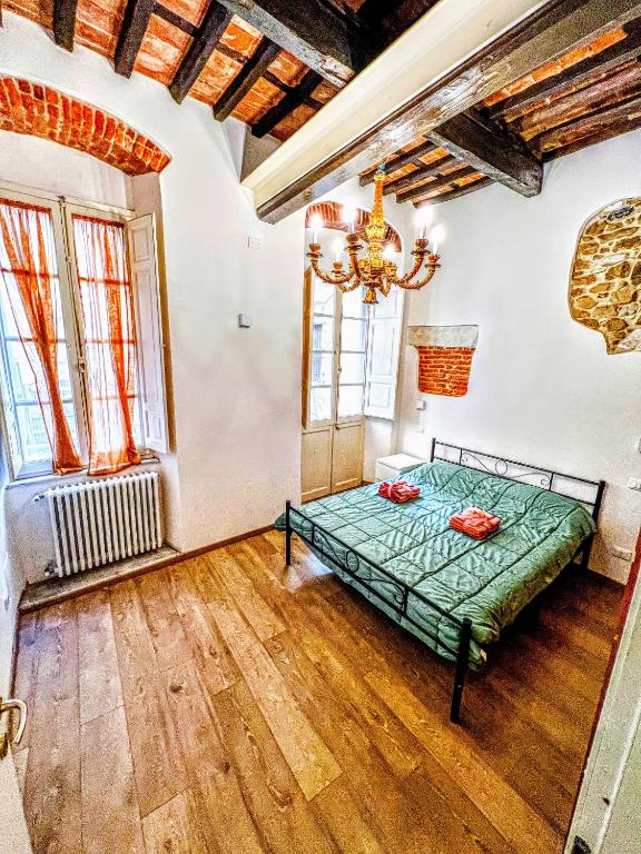 una camera con letto verde in una stanza con pavimenti in legno di -The Old Town Quarry- [Carrara Centro] a Carrara
