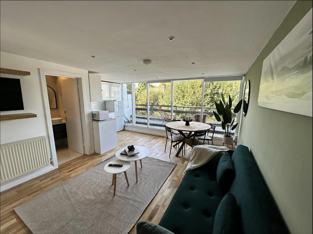 a living room with a couch and a table at Primrose Hill Apartment with Balcony in London