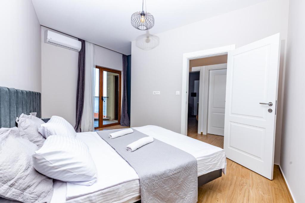 布德瓦Apartman DELUXE的一间卧室，配有两张铺有白色床单的床