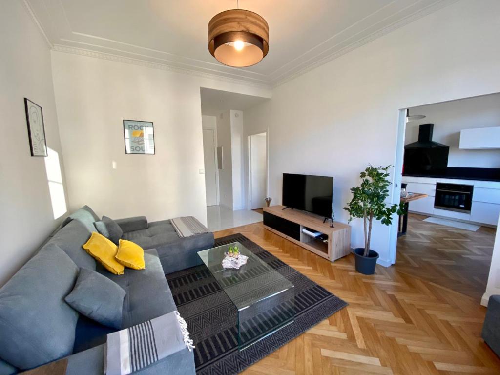 un salon avec un canapé et une télévision dans l'établissement Bel appartement proche plage, à Antibes