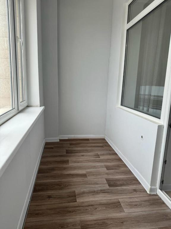 ein leeres Zimmer mit weißen Wänden und Holzböden in der Unterkunft Квартира in Taldykolʼ