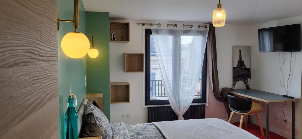 1 dormitorio con cama, ventana y escritorio en Green room, en Asnières-sur-Seine